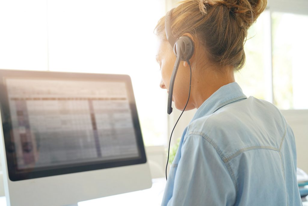 Customer service operator talking on phone in office